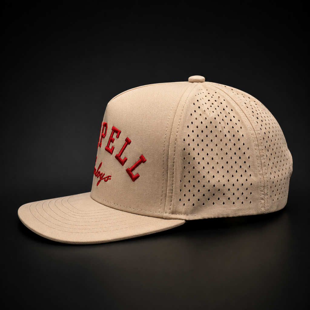 The Next Up tan kids performance snapback side studio view showing perforated panels on black background